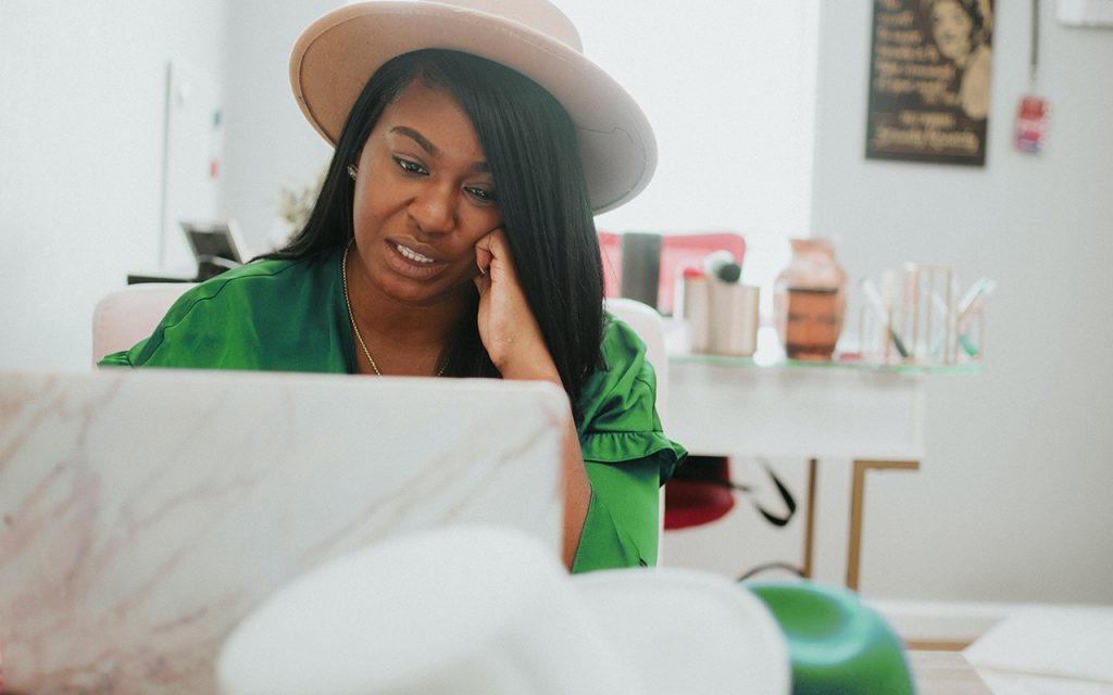Featured image for the article how to create an invoice [female entrepreneur working on her laptop]